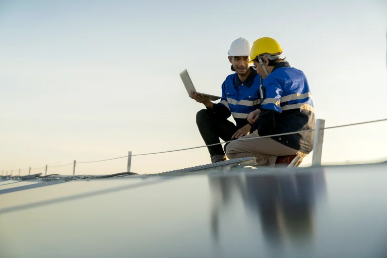 Two tradesmen on a roof looking at LLM on computer